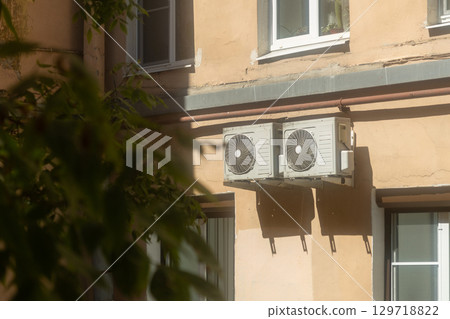 Air conditioners are installed on facade of building. device for comfortable living in hot weather. Air conditioners are installed on facade of building. device for comfortable living in hot weather. 129718822