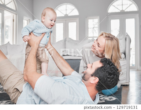 Relax, living room and parents playing with their baby together on the floor of their family home. Love, smile and happy mother and father bonding with their newborn child in the lounge of a house. 129719131