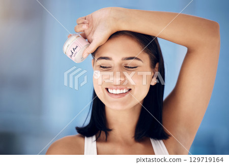 Skincare, beauty and woman with cream for face, dermatology marketing and container in a home bathroom. Facial wellness, smile and girl advertising a product for clean and healthy skin with a glow 129719164