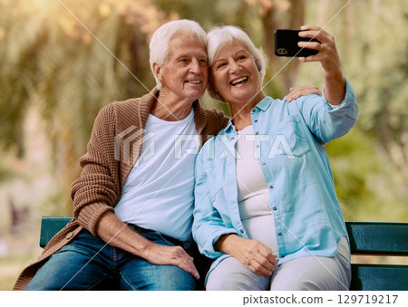 Senior couple, phone selfie and smile on park bench for love, care and social media profile picture of a happy retirement. Old man and woman outdoor together for happiness, support and bonding Senior couple, phone selfie and smile on park bench for love, care and social media profile picture of a happy retirement. Old man and woman outdoor together for happiness, support and bonding 129719217