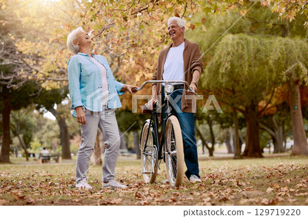 Nature, laugh and senior couple with bicycle to travel in autumn park for funny romantic date, outdoor peace or freedom. Love, retirement marriage bond and laughing man and woman with cycling bike 129719220