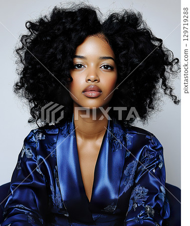 Young african female in blue silk robe with curly hair sitting. Young african female in blue silk robe with curly hair sitting. 129719288