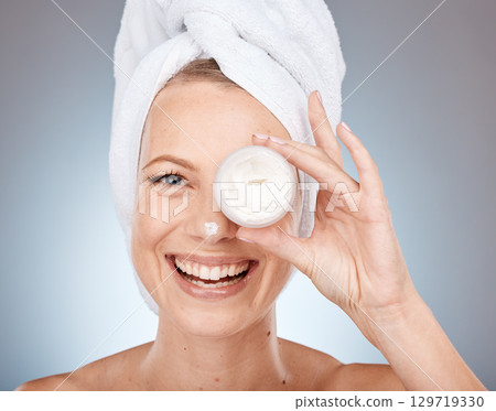 Woman, face or skincare cream in grooming routine, healthcare wellness or collagen treatment on gray studio background. Portrait, happy smile or beauty model or eye care product in Canada dermatology 129719330