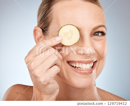 Woman, skincare face or cucumber in eye care on studio background for healthcare wellness, self care or Canada facial treatment. Portrait, smile or happy beauty model with vegetables in organic detox Woman, skincare face or cucumber in eye care on studio background for healthcare wellness, self care or Canada facial treatment. Portrait, smile or happy beauty model with vegetables in organic detox 129719412