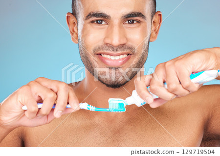 Portrait, man and brushing teeth with toothpaste, toothbrush and dental wellness for healthy lifestyle, cleaning or cosmetics on blue background in Turkey. Happy male model, oral mouth care and smile 129719504