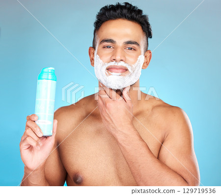 Face, skincare and man with shaving cream product in studio isolated on a blue background. Beauty, hair care and male model from Brazil with shave gel for beard grooming, cleaning and facial hygiene. 129719536