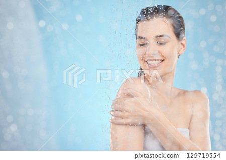 Cleaning, shower and woman with water in studio on blue background for beauty, wellness and body care. Spa hydration, skincare and happy girl washing for self care, health and hygiene in water drops Cleaning, shower and woman with water in studio on blue background for beauty, wellness and body care. Spa hydration, skincare and happy girl washing for self care, health and hygiene in water drops 129719554