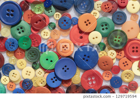 Top view of A diverse collection of colorful sewing buttons. Various shapes, sizes, and patterns. Craft background, 129719594