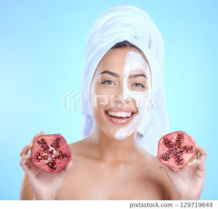 Face mask, beauty skincare and woman with pomegranate in studio isolated on a blue background. Half facial mask, spa treatment and female model holding fruits for nutrition, vitamin c or healthy diet Face mask, beauty skincare and woman with pomegranate in studio isolated on a blue background. Half facial mask, spa treatment and female model holding fruits for nutrition, vitamin c or healthy diet 129719648