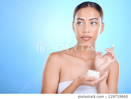 Beauty, woman and face cream for skincare, facial and hygiene on blue background mockup. Face, skin and sunscreen product for girl model relax in studio for luxury mask, wellness and moisturizer Beauty, woman and face cream for skincare, facial and hygiene on blue background mockup. Face, skin and sunscreen product for girl model relax in studio for luxury mask, wellness and moisturizer 129719660