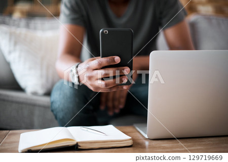 Hands, phone and man with laptop planning on sofa in communication or texting with technology at home. Hand of student chatting on mobile phone, studying or working remote on project in living room Hands, phone and man with laptop planning on sofa in communication or texting with technology at home. Hand of student chatting on mobile phone, studying or working remote on project in living room 129719669