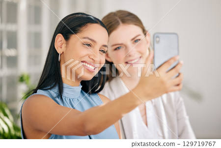 Business women taking team selfie for social media on phone as a happy, smile and success collaboration in a startup agency. Friends, diversity staff and creative worker with motivation in office Business women taking team selfie for social media on phone as a happy, smile and success collaboration in a startup agency. Friends, diversity staff and creative worker with motivation in office 129719767