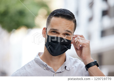 Freedom, end of covid and man removing face mask after corona virus with bokeh urban city. Trust and compliance in post covid 19 portrait or headshot of young person free after getting vaccine 129719770
