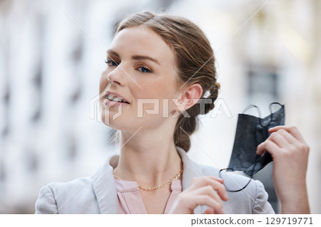 Covid, compliance and freedom with face mask removal by woman outdoors, happy, relieved and free in city. Carefree female confident about end of the pandemic, looking proud after getting the vaccine 129719771