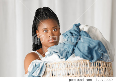 Portrait, laundry and wow with a black woman cleaner carrying a basket of clothing for washing in her home. Cleaning, face and shock with a female housekeeper doing housework or chores with surprise 129720002