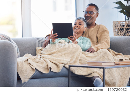 Tablet, relax and movies with a senior couple on the sofa to relaxing while using an online streaming service. Happy, technology and internet with a mature man and woman under a blanket at home Tablet, relax and movies with a senior couple on the sofa to relaxing while using an online streaming service. Happy, technology and internet with a mature man and woman under a blanket at home 129720082