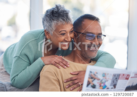 Love, senior couple and reading newspaper in living room of home. Retirement, relax and happy elderly man and woman embrace in house, hugging or cuddle while looking at news article or story in house 129720087