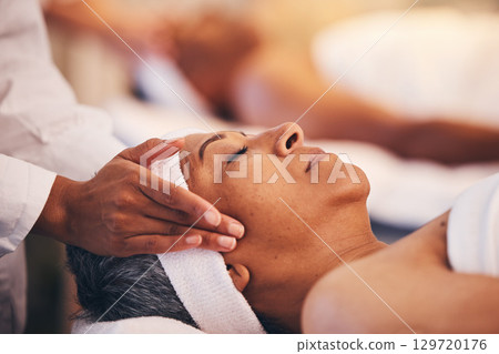Hands, head and massage with a woman in a spa for wellness or luxury treatment to relax and rest. Face, zen and stress relied with a senior female relaxing in a health salon for physical therapy 129720176