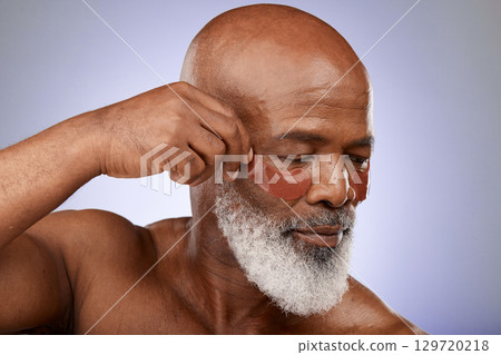 Senior man, eyes mask and face skincare wellness in studio for beauty, cosmetics dermatology or skin treatment. Facial care, natural eyecare product and body care cosmetology in purple background Senior man, eyes mask and face skincare wellness in studio for beauty, cosmetics dermatology or skin treatment. Facial care, natural eyecare product and body care cosmetology in purple background 129720218