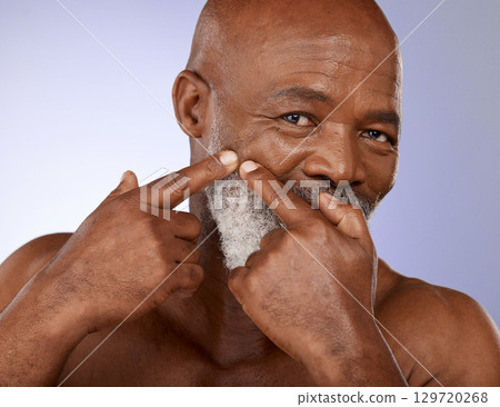 Face, beauty and skincare with a senior black man checking his skin for a pimple or zit in studio on a purple background. Portrait, wellness and facial cleaning with a mature male posing for hygiene Face, beauty and skincare with a senior black man checking his skin for a pimple or zit in studio on a purple background. Portrait, wellness and facial cleaning with a mature male posing for hygiene 129720268