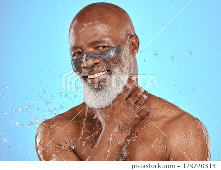Portrait, facial and senior man in studio for wellness, cleaning and skin mask with water splash on blue background. Face, elderly man and skincare mask, beauty splash and luxury product in shower Portrait, facial and senior man in studio for wellness, cleaning and skin mask with water splash on blue background. Face, elderly man and skincare mask, beauty splash and luxury product in shower 129720313