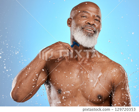 Skincare, shower and senior black man in studio with happy portrait for cleaning, healthy body and water splash on blue background. Cosmetics, dermatology and aesthetic of african elderly model glow 129720353