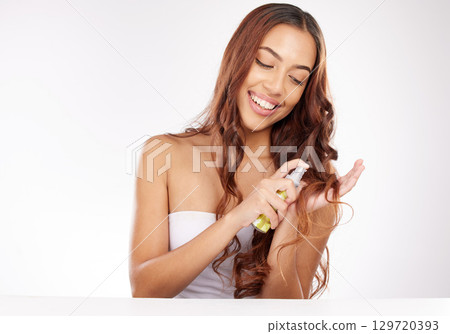 Beauty, hair and keratin with a model black woman spraying natural treatment in studio on a gray background. Salon, wellness and haircare with an attractive young female using a hair product 129720393
