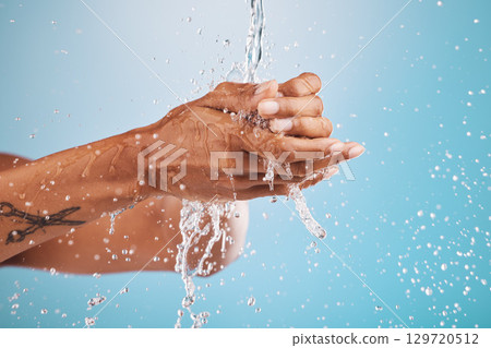 Water, washing and cleaning hands on blue background for hygiene, healthcare and cleansing in studio. Wellness, hydration and person washing hands for germ protection, bacteria and safety from virus Water, washing and cleaning hands on blue background for hygiene, healthcare and cleansing in studio. Wellness, hydration and person washing hands for germ protection, bacteria and safety from virus 129720512