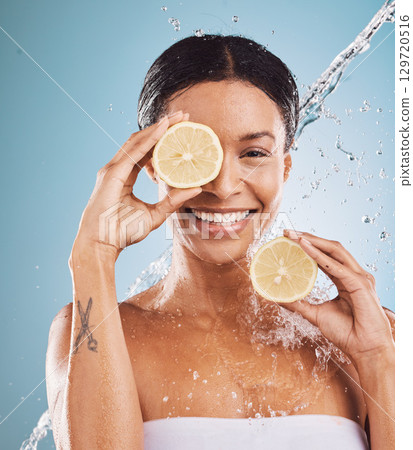 Lemon, portrait and skincare black woman in studio water splash for cosmetics, makeup or facial cleaning product. Skin care, vitamin c and healthy model face with fruit for dermatology on blue mockup Lemon, portrait and skincare black woman in studio water splash for cosmetics, makeup or facial cleaning product. Skin care, vitamin c and healthy model face with fruit for dermatology on blue mockup 129720516