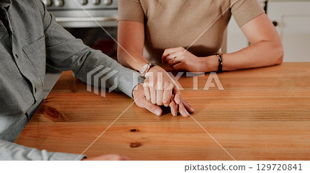 Support, holding hands and couple with marriage, home and mental health problem zoom on table for help, trust and love. Sad people hand holding for depression, death or bad news with care and empathy 129720841