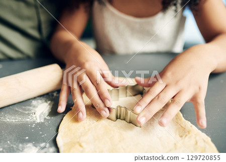 Family, hands baking and christmas tree cookies being made with a cutter while bonding and learning. Sweets, dessert and biscuit treat being baked with dough by a child and her parent at xmas Family, hands baking and christmas tree cookies being made with a cutter while bonding and learning. Sweets, dessert and biscuit treat being baked with dough by a child and her parent at xmas 129720855