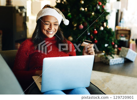 Credit card, laptop and woman online shopping on Christmas day in living room. Fintech, xmas holiday and happy female from India on computer, virtual store or internet shop buying gifts or presents. Credit card, laptop and woman online shopping on Christmas day in living room. Fintech, xmas holiday and happy female from India on computer, virtual store or internet shop buying gifts or presents. 129720901