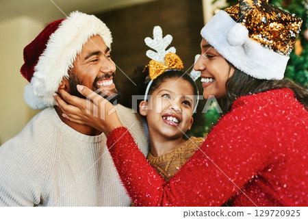 Family, christmas celebration and love with happy smile and festive holiday, care. and decoration with hat in home. Mother, father and girl together in house to celebrate xmas event in family home Family, christmas celebration and love with happy smile and festive holiday, care. and decoration with hat in home. Mother, father and girl together in house to celebrate xmas event in family home 129720925