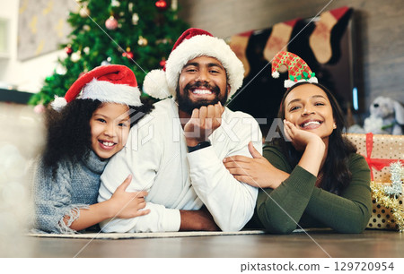 Christmas, portrait and family, kids and parents in lounge, winter celebration and love, care and happiness together. Happy family, girl and child celebrate festive holiday, santa hats or living room 129720954
