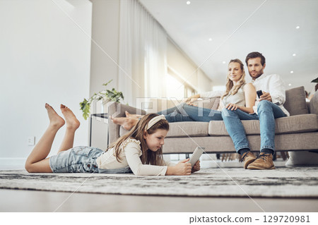 Family, relax or child on tablet in living room, house or home live streaming, movies channel or internet show bonding. Parents, child or kid girl on technology games, television or watching tv media 129720981