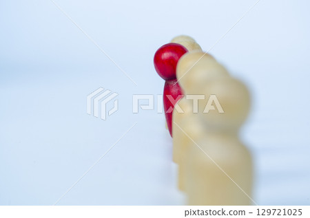 A single red figure voicing out from other wooden figures, representing leadership or unfair treatment or discrimination concept A single red figure voicing out from other wooden figures, representing leadership or unfair treatment or discrimination concept 129721025