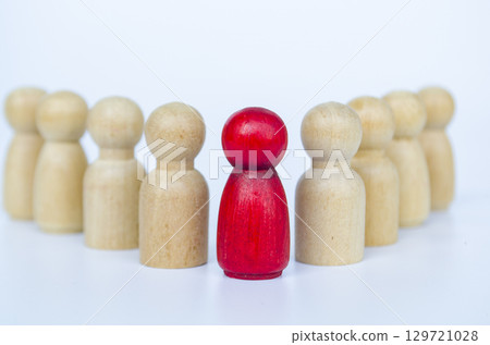 A red figure embraced by wooden figures, representing leadership or diversity or belonging concept A red figure embraced by wooden figures, representing leadership or diversity or belonging concept 129721028