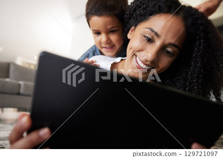 Love, mother with son on back and on floor with tablet, reading and learning together for quality time. Happy, mama and boy on ground, device and bonding on break, weekend and enjoy online videos 129721097