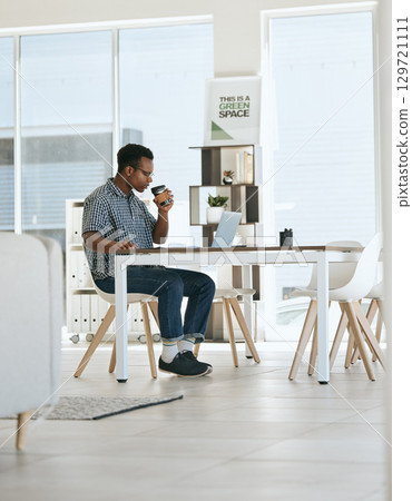 Black man, coffee drinking and office with laptop, table and thinking in marketing startup business. Man, drink espresso or tea at desk with computer, reading and planning for digital marketing job Black man, coffee drinking and office with laptop, table and thinking in marketing startup business. Man, drink espresso or tea at desk with computer, reading and planning for digital marketing job 129721111