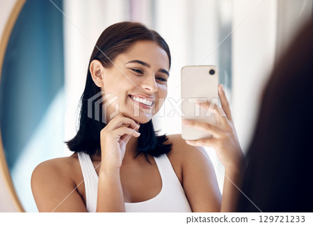 Mirror selfie, happy woman and phone, beauty and skincare in bathroom of home. Smile young girl taking photograph in reflection, mobile and social media influencer doing morning routine vlog 129721233