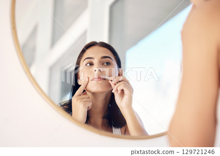 Beauty, mirror and tweezers with a woman in the bathroom of her home for hair removal or skincare. Facial, wellness and cleaning with an attractive young female face in her house in the morning Beauty, mirror and tweezers with a woman in the bathroom of her home for hair removal or skincare. Facial, wellness and cleaning with an attractive young female face in her house in the morning 129721246