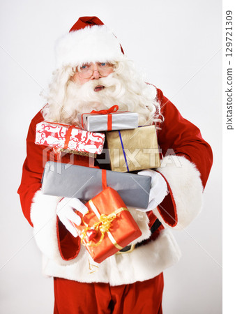 Senior man, santa claus or presents by white background in studio for delivery, celebration or holiday event. Retirement elderly, festive christmas costume or xmas parcel gift box on mockup backdrop 129721309