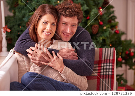 Christmas portrait, couple and hug on sofa in home with affection and love. Xmas holiday, romance and happy man and woman embrace, bonding or cuddle on couch enjoying quality time together in house. 129721389