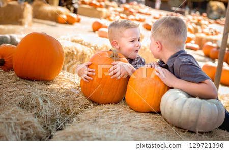Two Boys Having Fun at the Pumpkin Patch on a Sunny Fall Day. 129721390