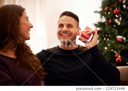 Couple, Christmas and love with guess gift box for surprise, happiness and holiday excitement. Happy, marriage and present for partner guessing what is inside with cheerful smile in home. 129721446