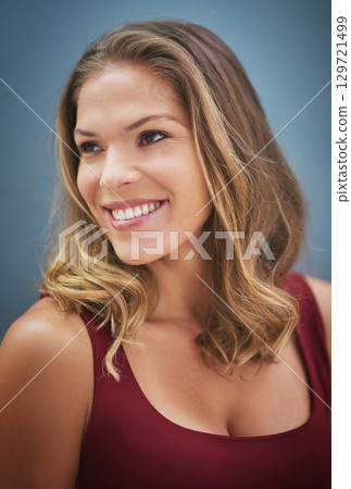 Thinking, happy and woman with a vision, smile and happiness against a blue background in studio. Idea, hair care and face of a salon model with natural beauty, young and confident on a wall Thinking, happy and woman with a vision, smile and happiness against a blue background in studio. Idea, hair care and face of a salon model with natural beauty, young and confident on a wall 129721499