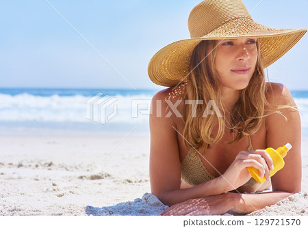 Woman, beach and sunscreen while on a tropical vacation in Bali for rest and relaxation. Skincare, protection and suncream with a female tourist on a seaside holiday while using cream on the sand 129721570