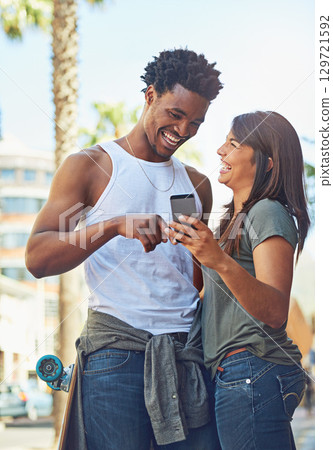 Happy, smile and couple on a phone in city watching a comic, comedy or funny video on social media. Happiness, love and interracial man and woman scrolling online on the internet in urban town road. 129721592