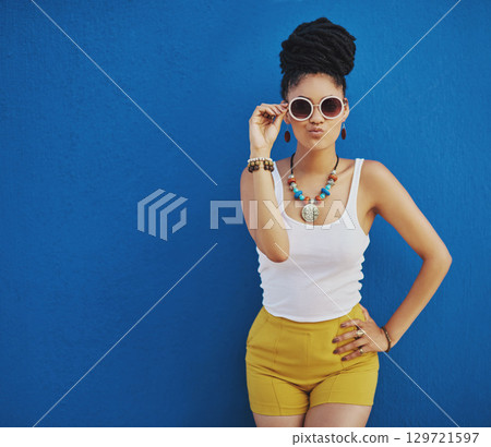 Fashion, summer and black woman with sunglasses on blue background wall in city on weekend. Freedom, beauty and girl enjoy holiday, travel and vacation in urban town with trendy clothes and cosmetics Fashion, summer and black woman with sunglasses on blue background wall in city on weekend. Freedom, beauty and girl enjoy holiday, travel and vacation in urban town with trendy clothes and cosmetics 129721597