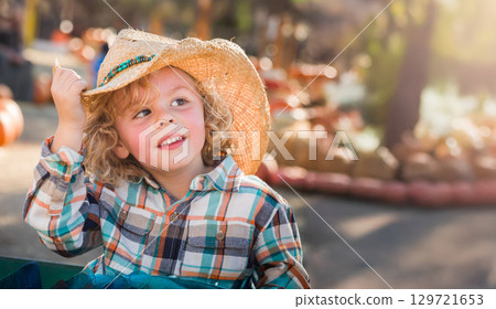 Cute Young Boy Wearing Cowboy Hat at Pumpkin Patch Farm. 129721653